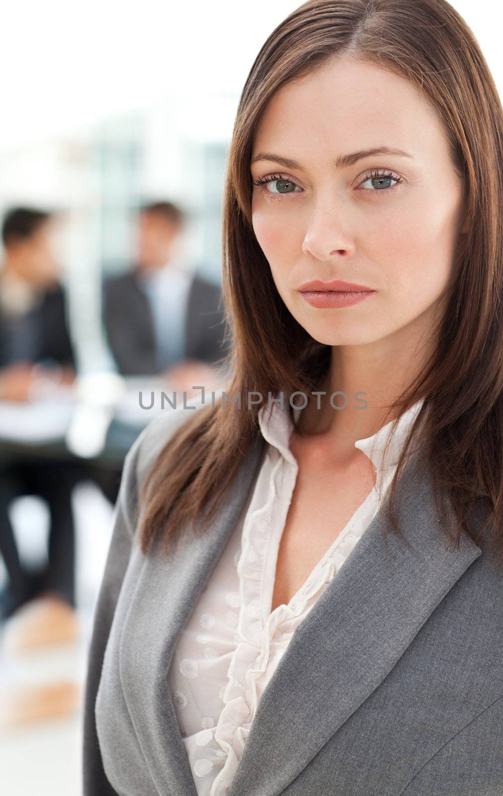 Charismatic businesswoman in the foreground while his colleagues by Wavebreakmedia