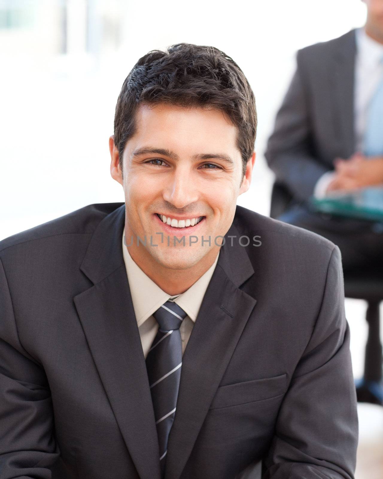 Happy businessman in the foreground during a meeting with a friend at the office