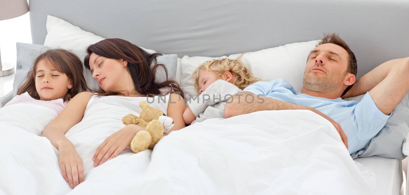 Cute family sleeping together by Wavebreakmedia