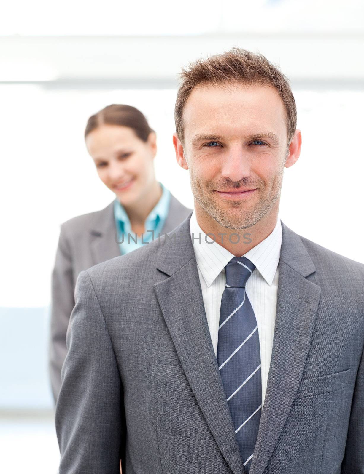 Two smiling business people posing in a row by Wavebreakmedia