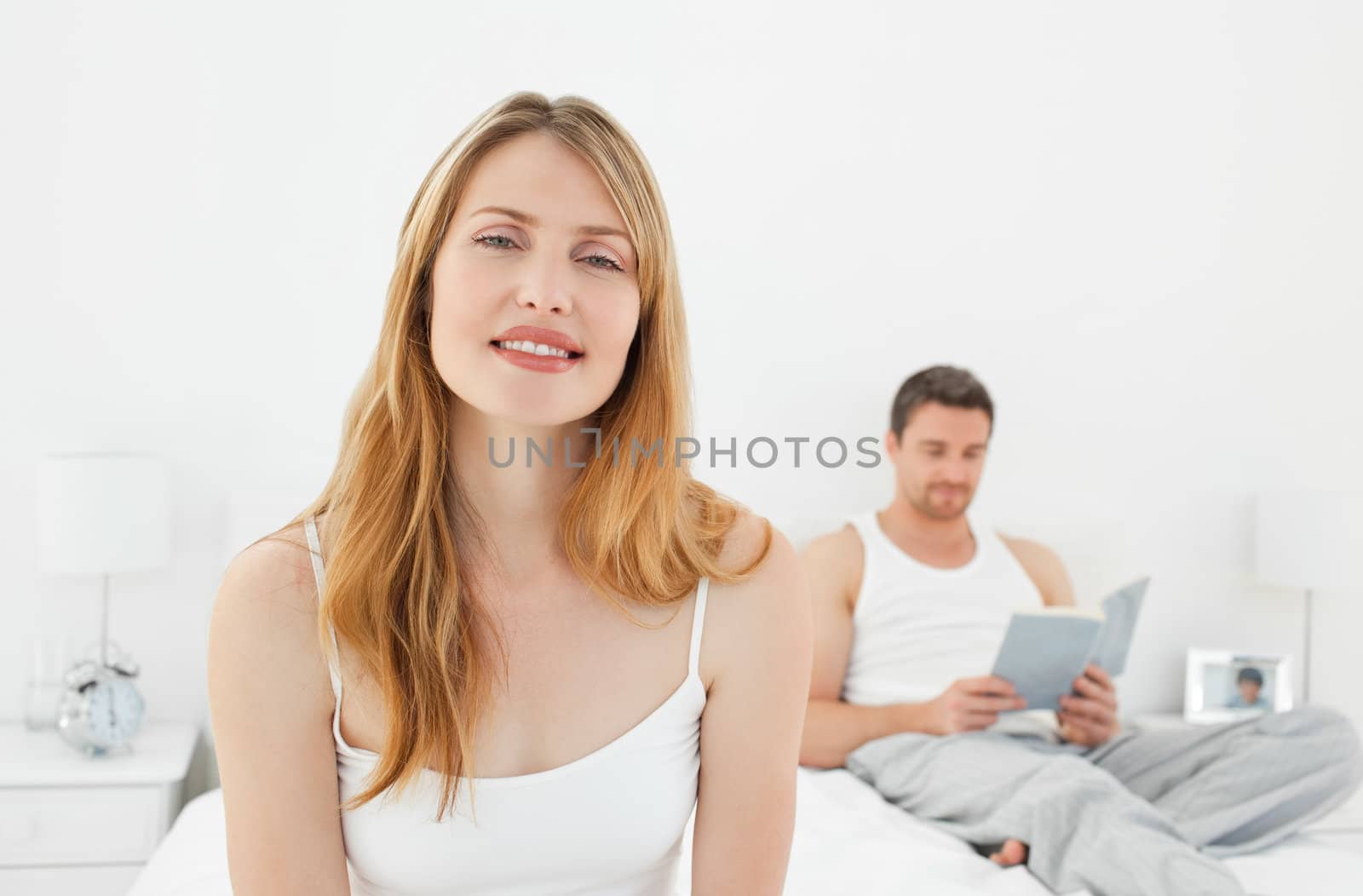Smiling woman looking at the camera on her bed