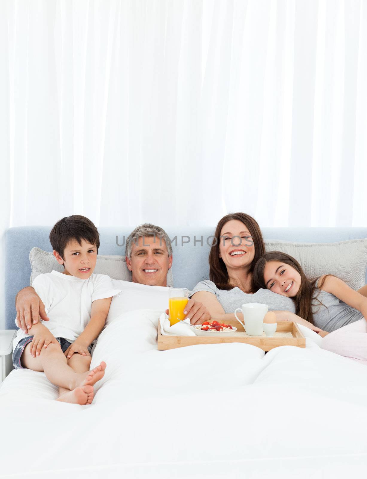 Family having breakfast in their bed at home