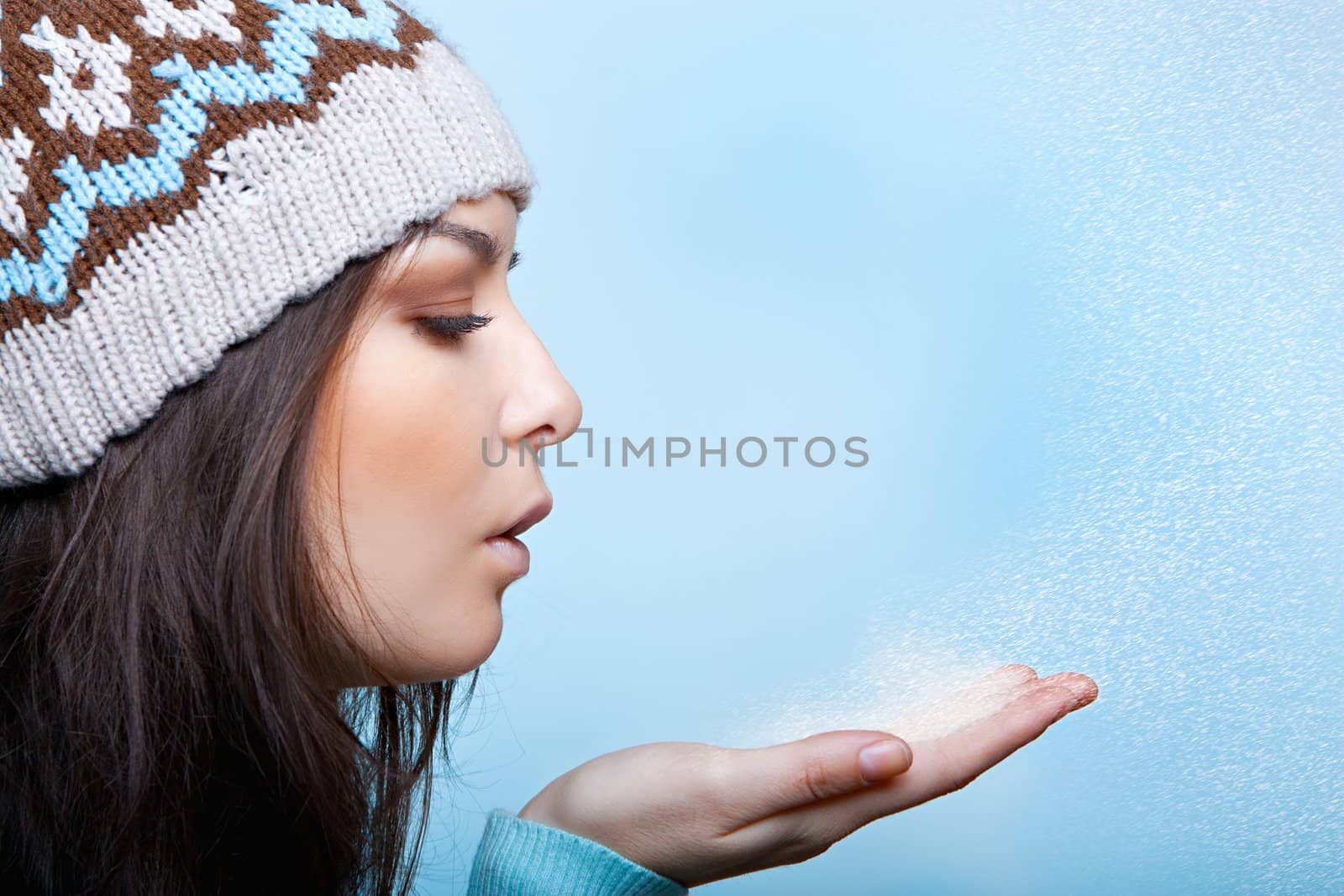 woman blows the snow on a blue background