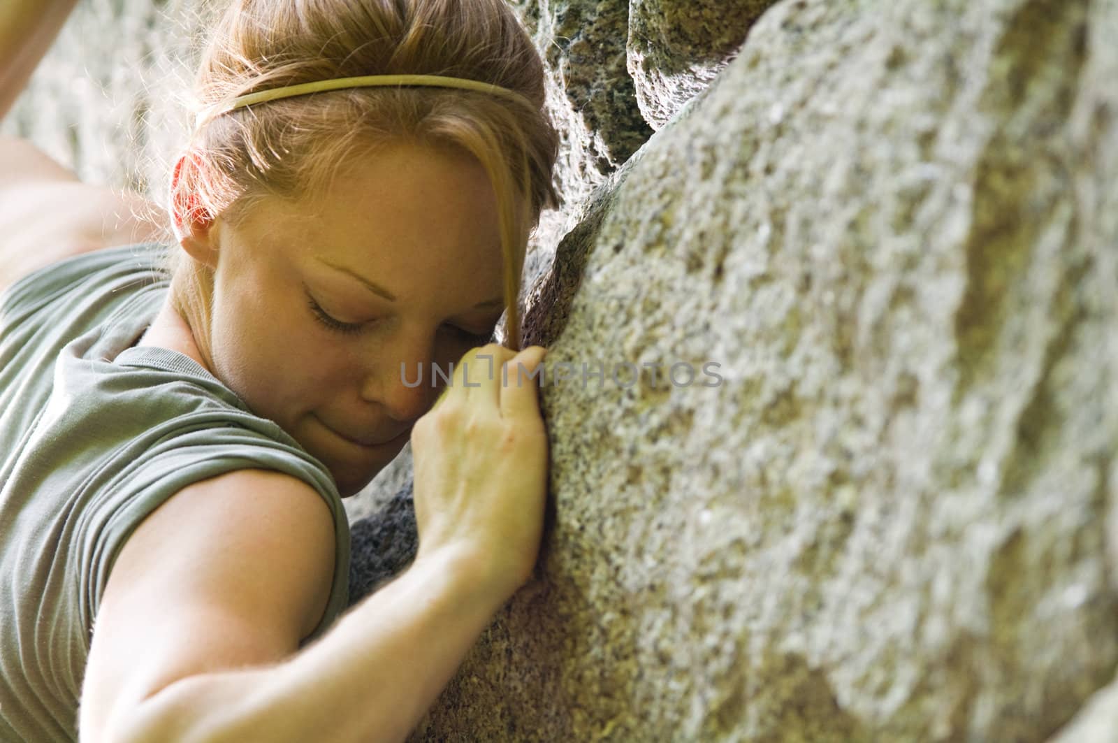 Female rock climber attempts to make her way up a stone structure