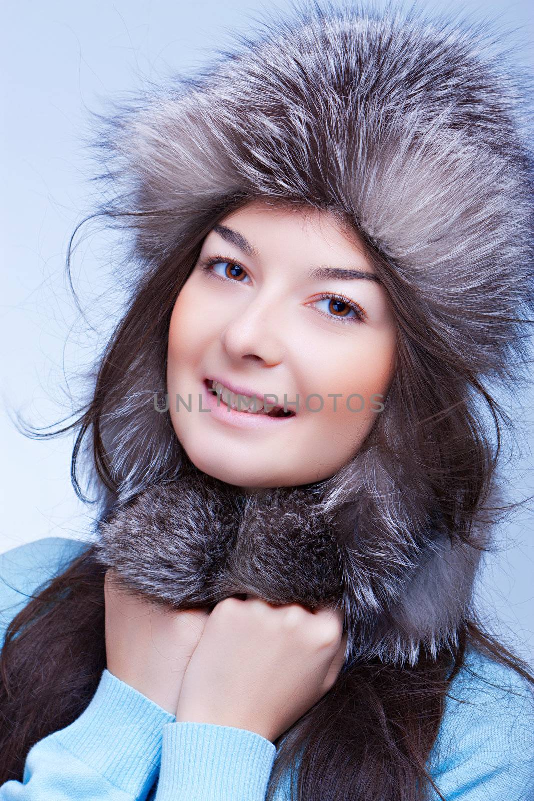 happiest woman in a fur cap on the blue background