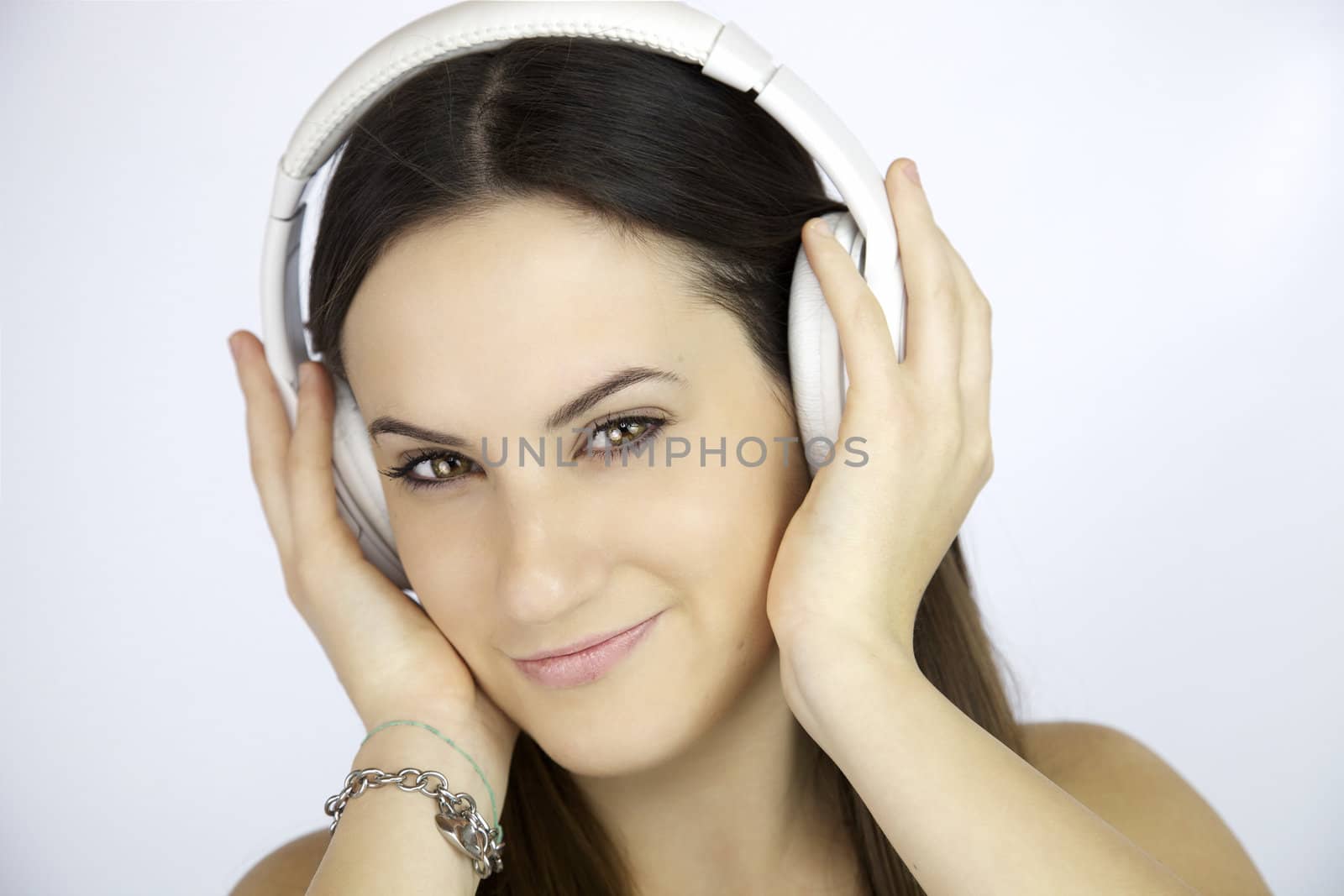 Young woman listening music with white headphones