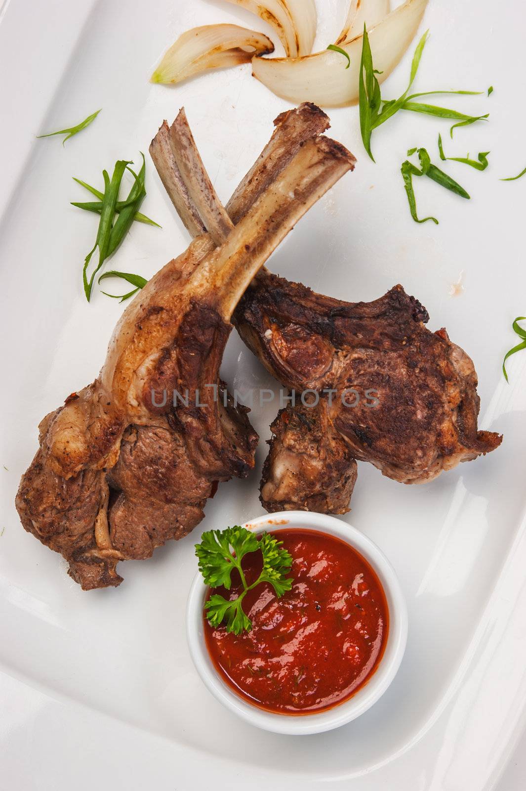 Meat ribs on the plate with tomato sauce