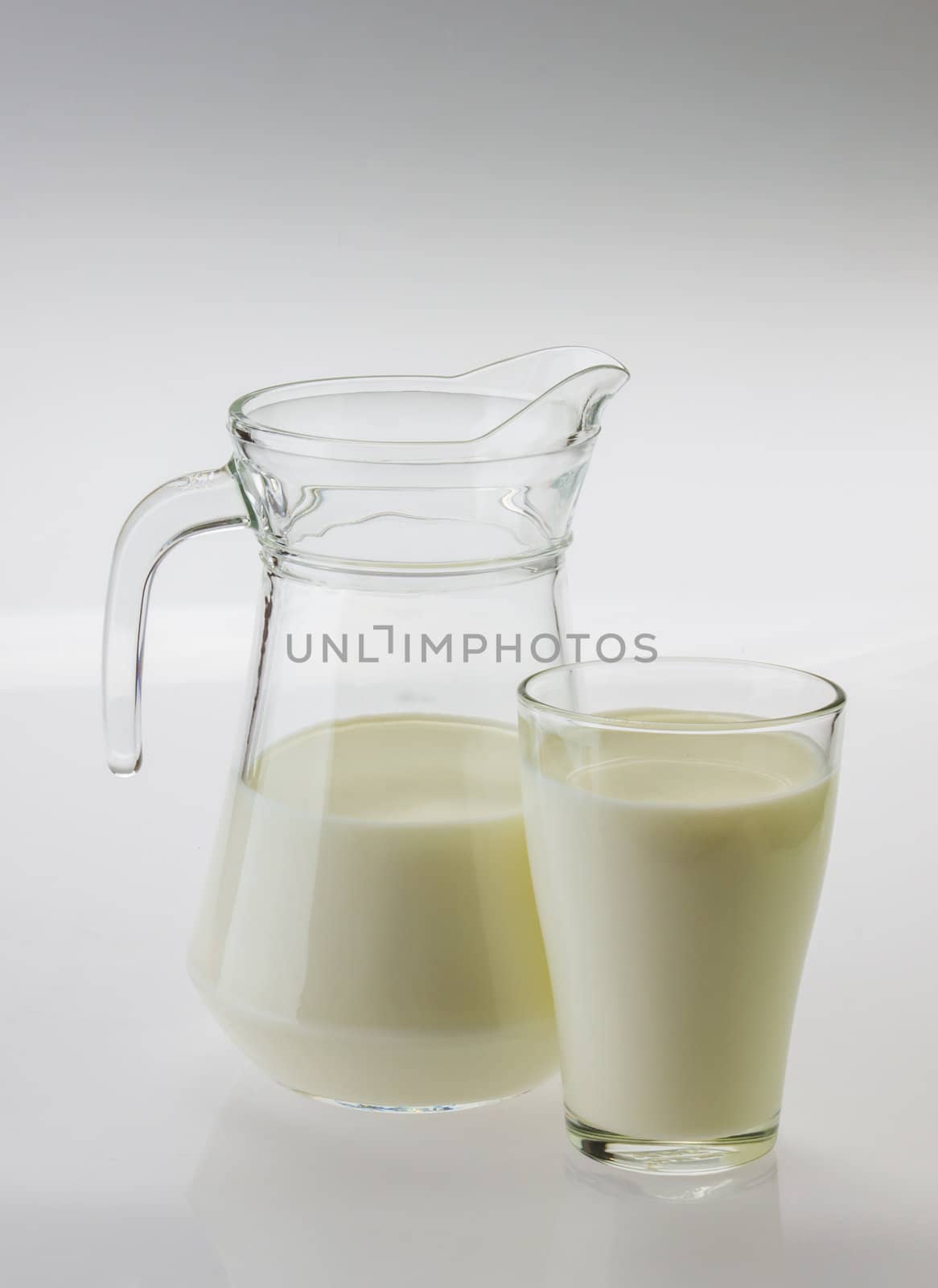 milk in a jug and glass  on white background