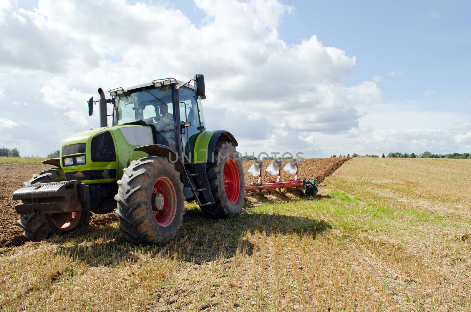 Closeup of tractor plowing agricultural field in autumn.