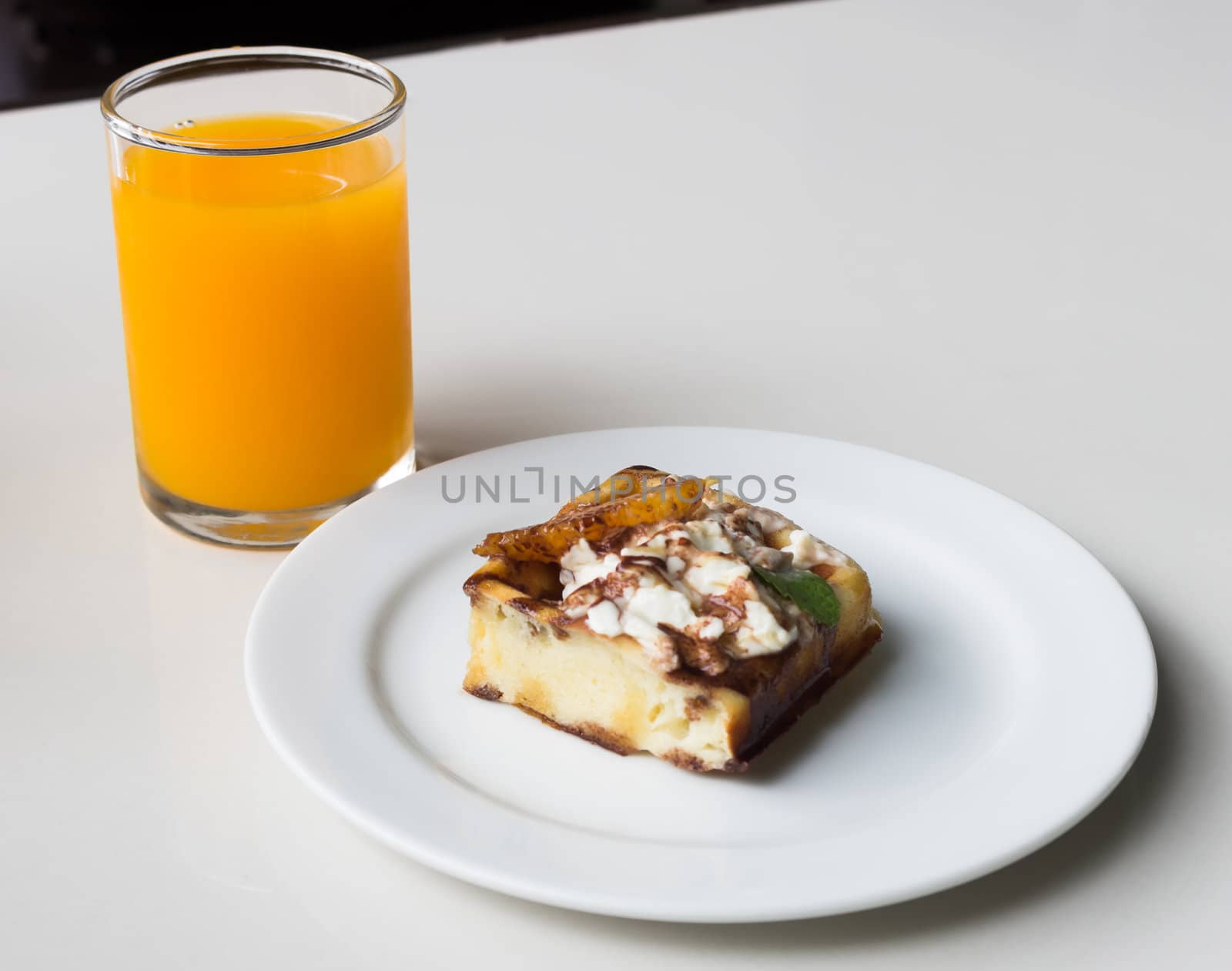Homemade fresh sweet waffles cake on plate with orange juice.