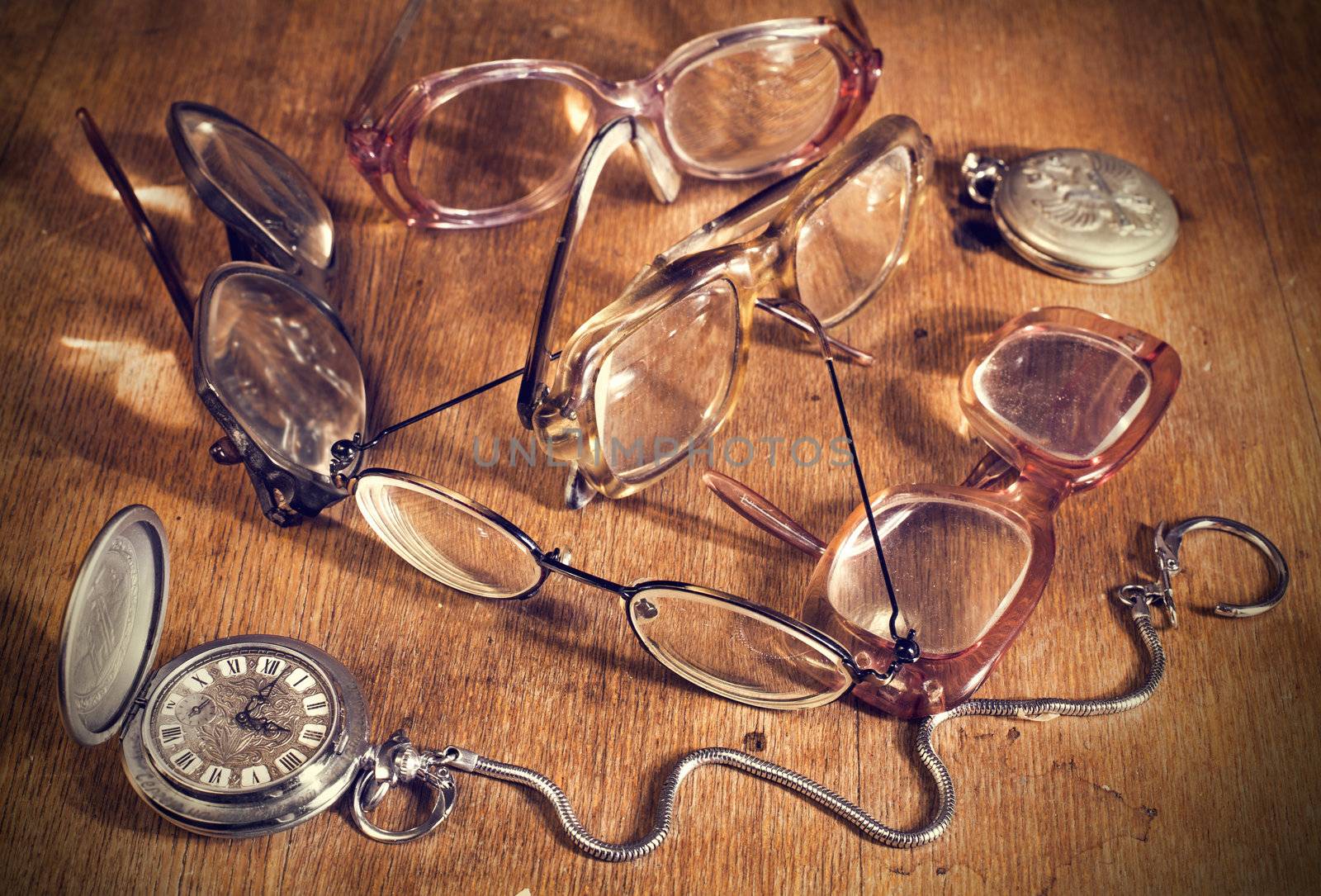 many Glasses and watch lying on a wooden table