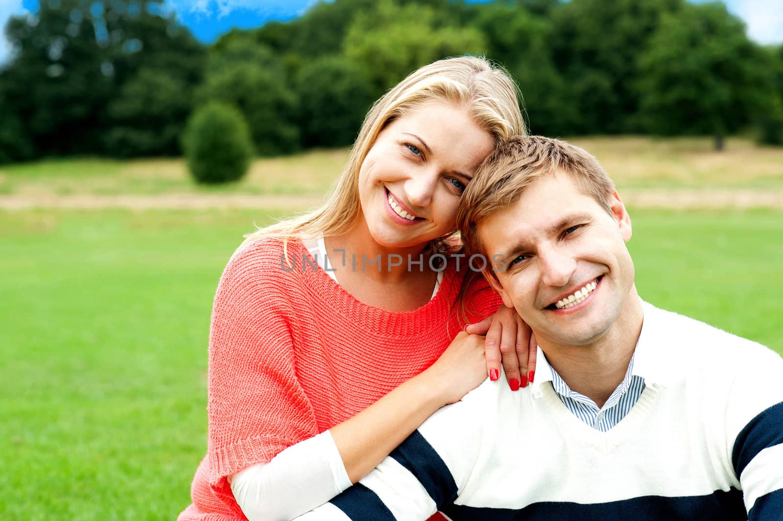 Lovely young couple striking a smiling pose, outdoors