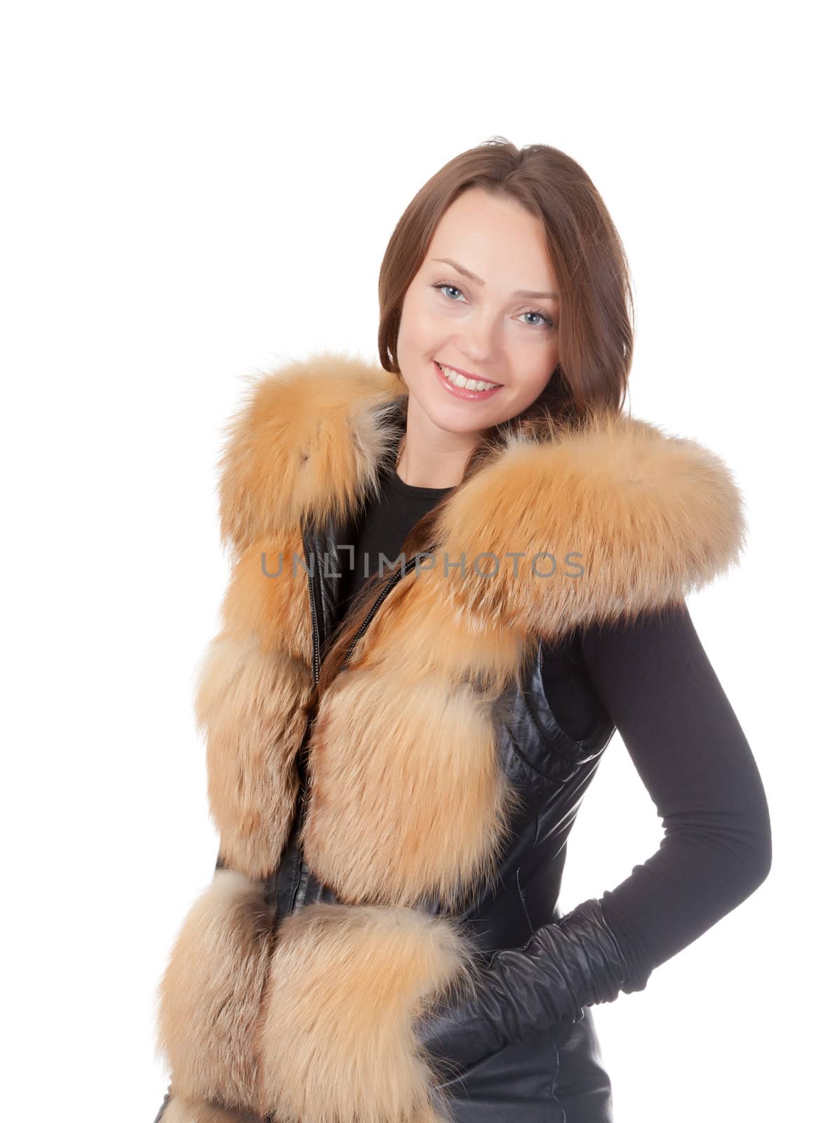 Stylish relaxed young woman in winter fur jacket standing with her hands in her pocket isolated on white