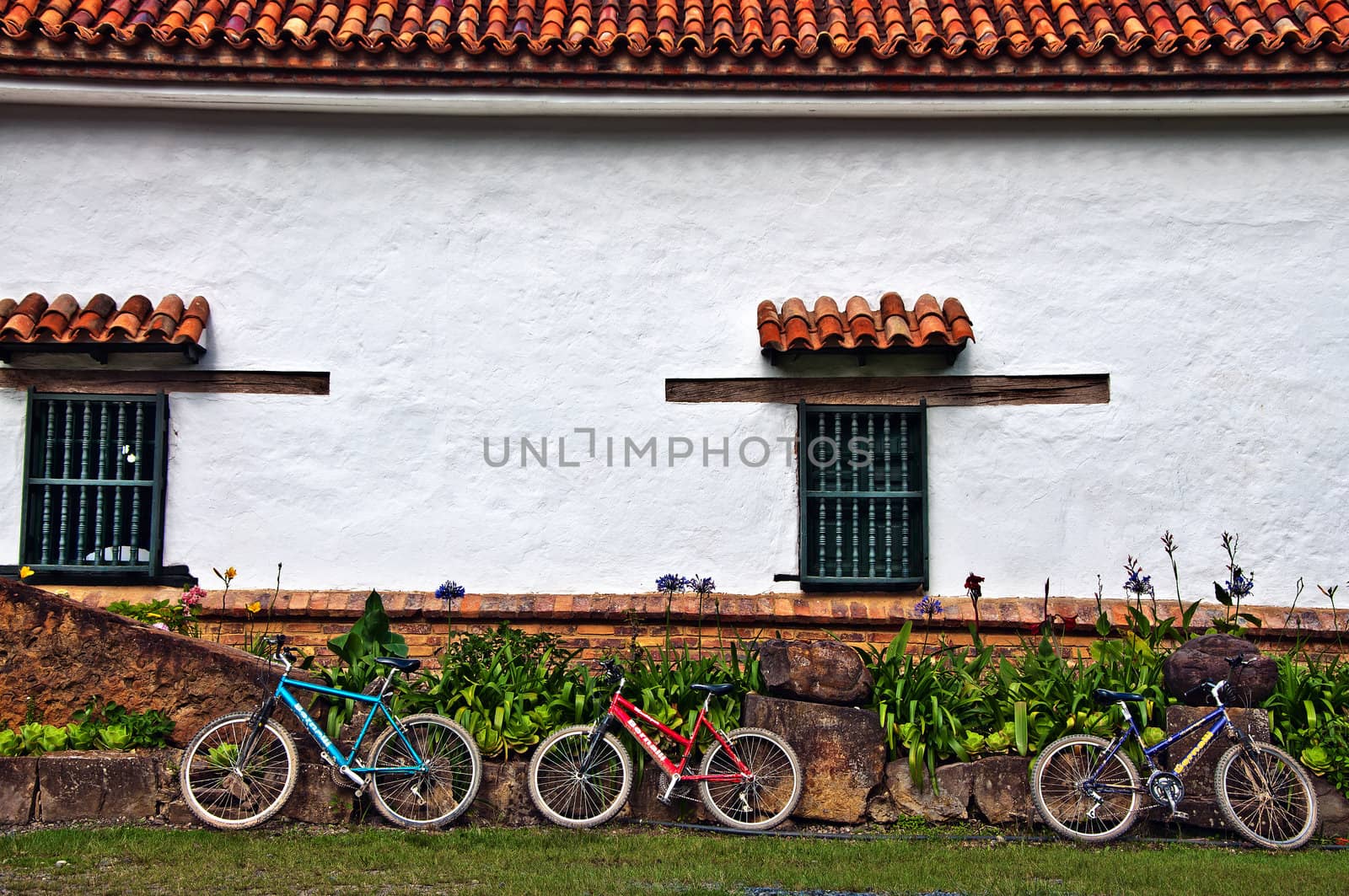 Three bicycles resting against the wall of an old Spanish Monastery.