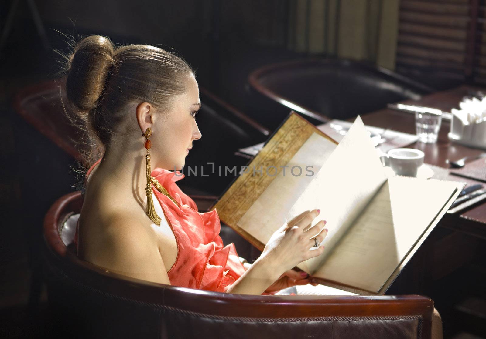 beautiful woman looks on menu at expensive restaurant