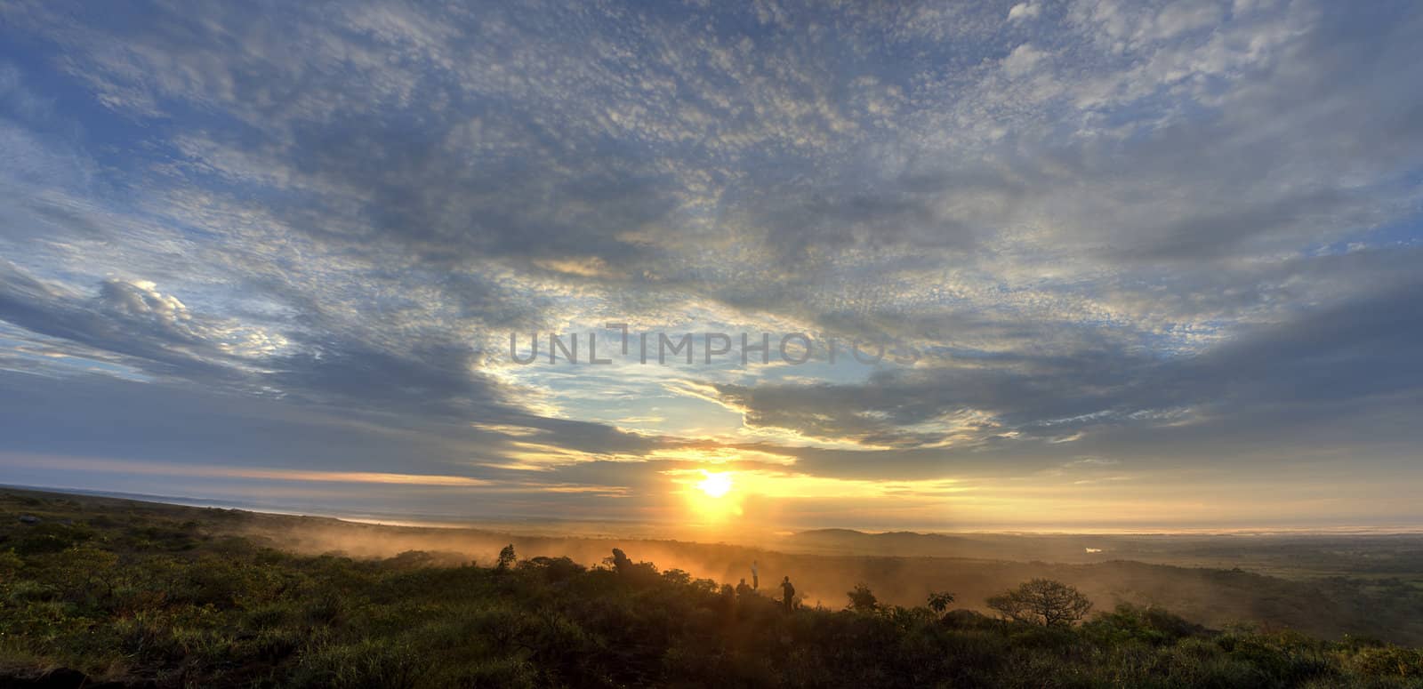 Sunrise in the Colombian plains with people in the foreground.