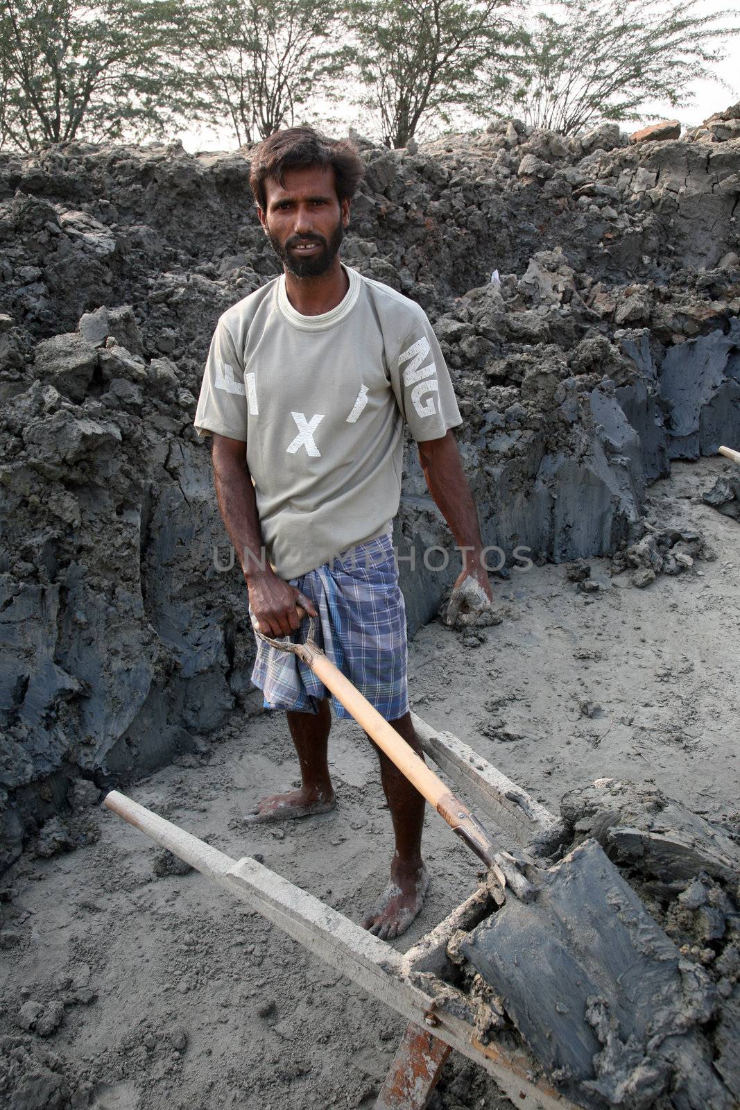 Laborers are carrying soil from the river and keeping them in the brick field area in Sarberia, West Bengal, India by atlas