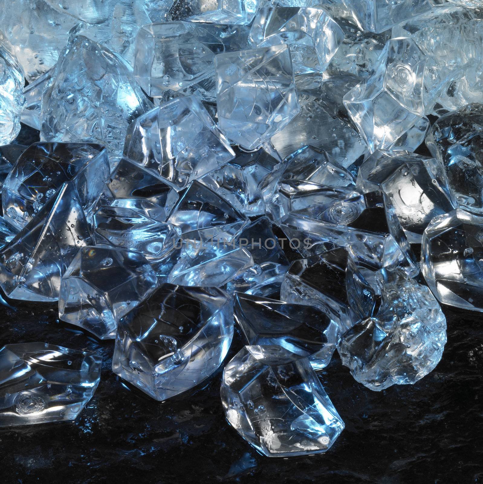 studio photography of blue illuminated ice cubes in dark back