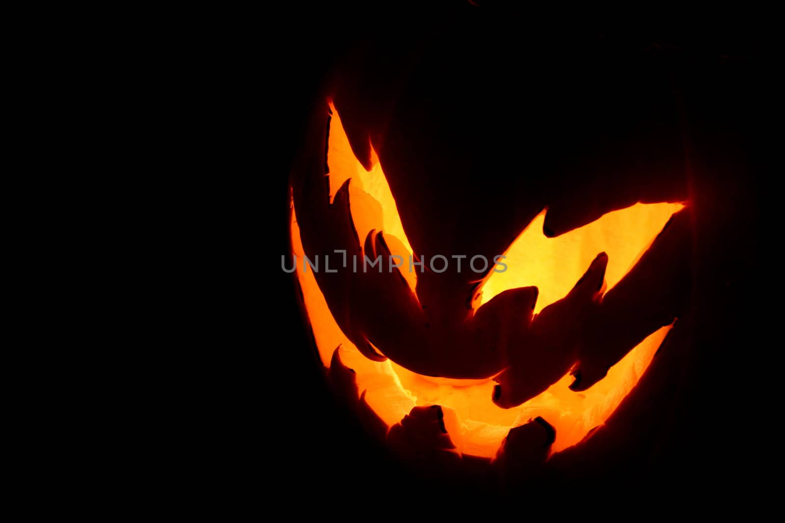 A spooky pumpkin face glowing on Halloween night.