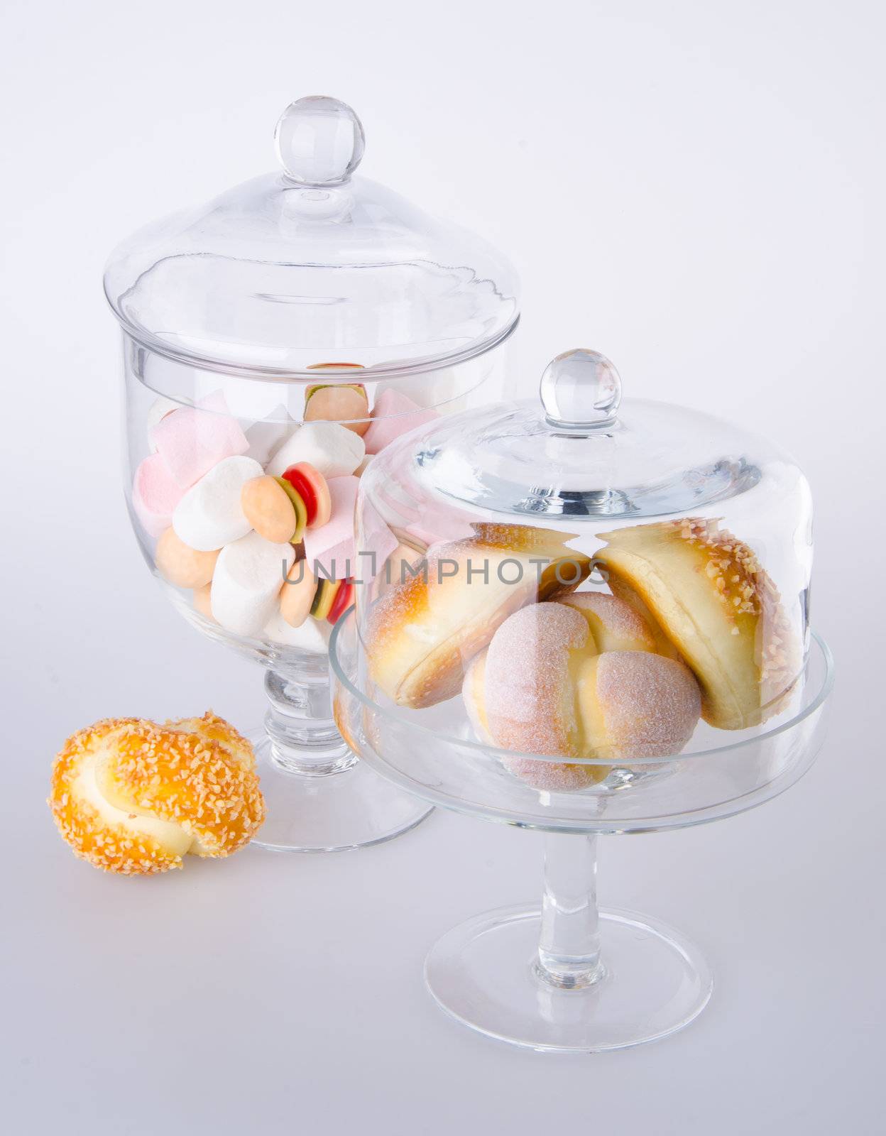 Donut, bun, cookie & glass jar on the background