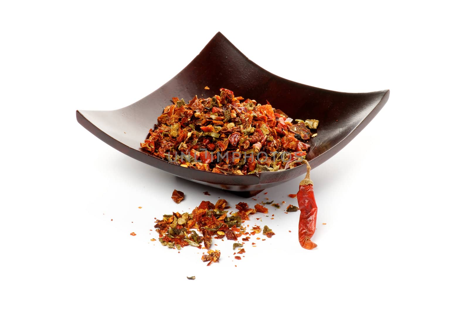 Perfect Dried Crushed Paprika, Chili Seeds and Chili Pepper on Black Plate isolated on white background