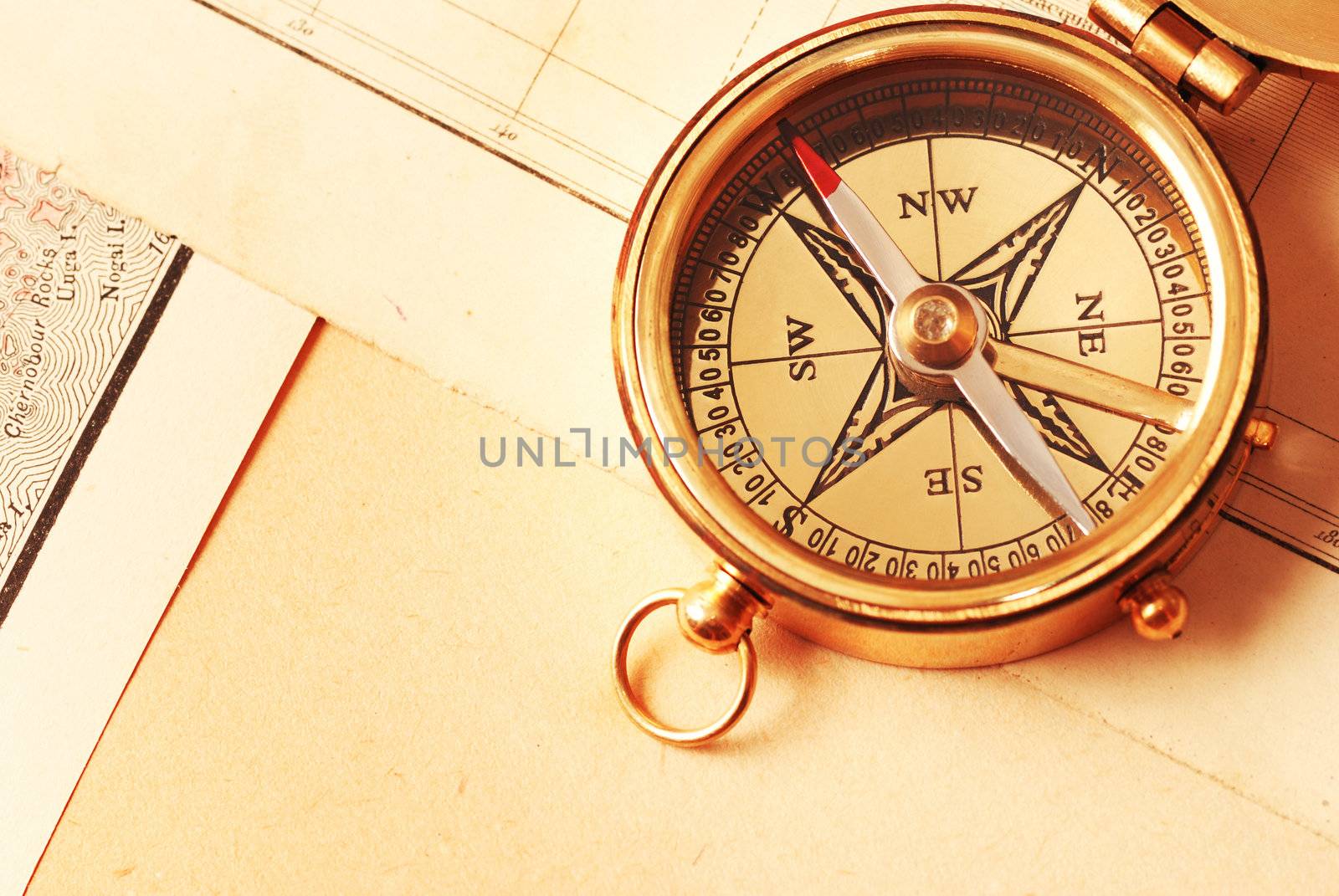 Antique brass compass over old map by haveseen