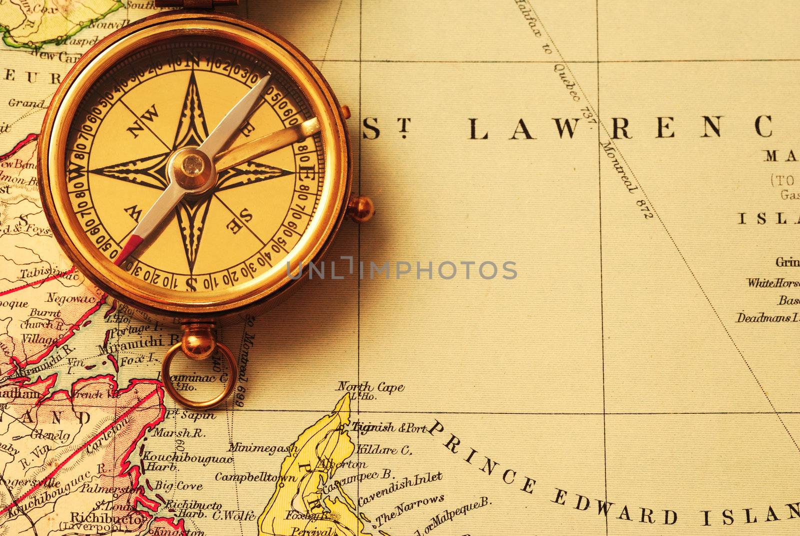 Antique brass compass over old Canadian map background