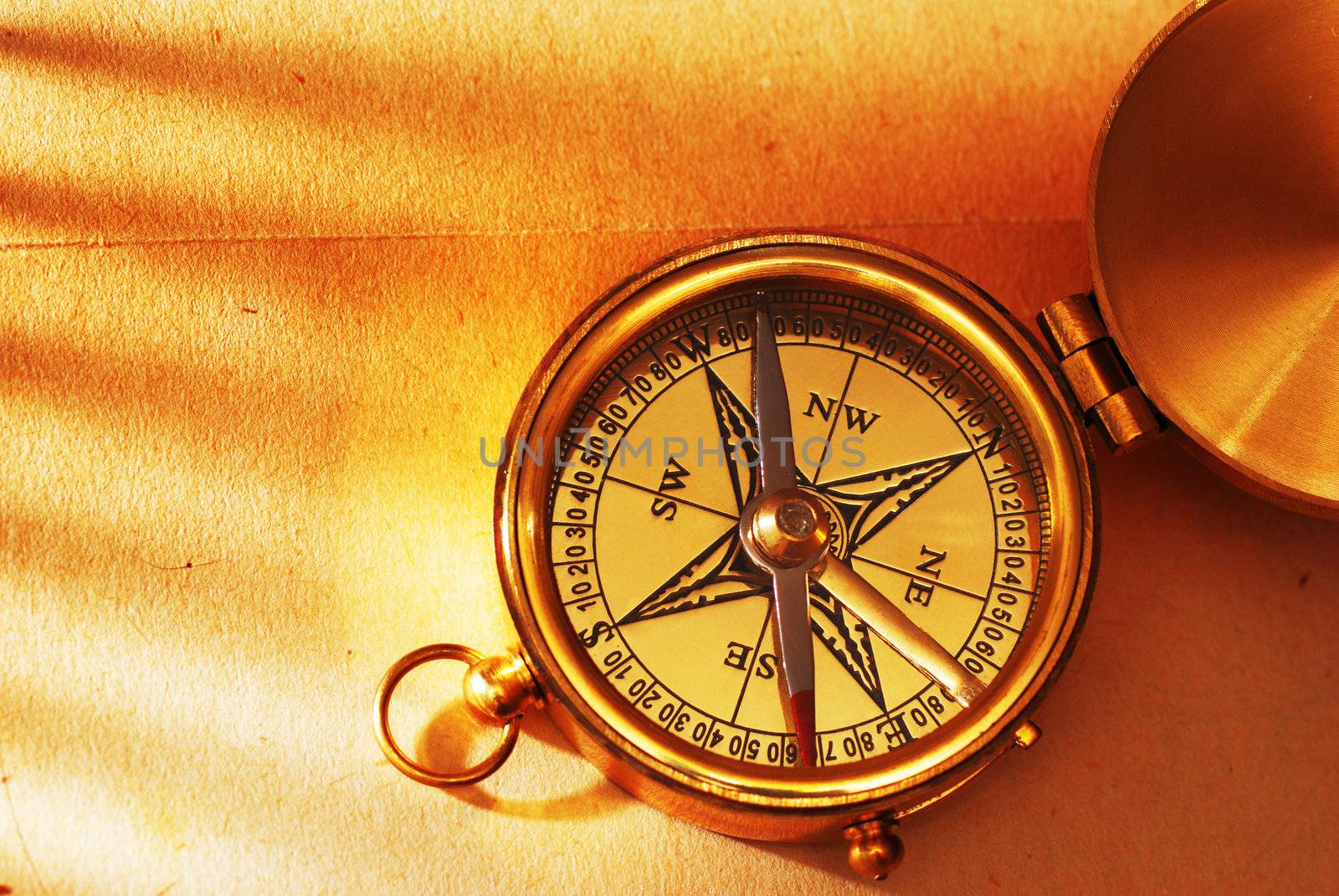 Antique brass compass over old map background