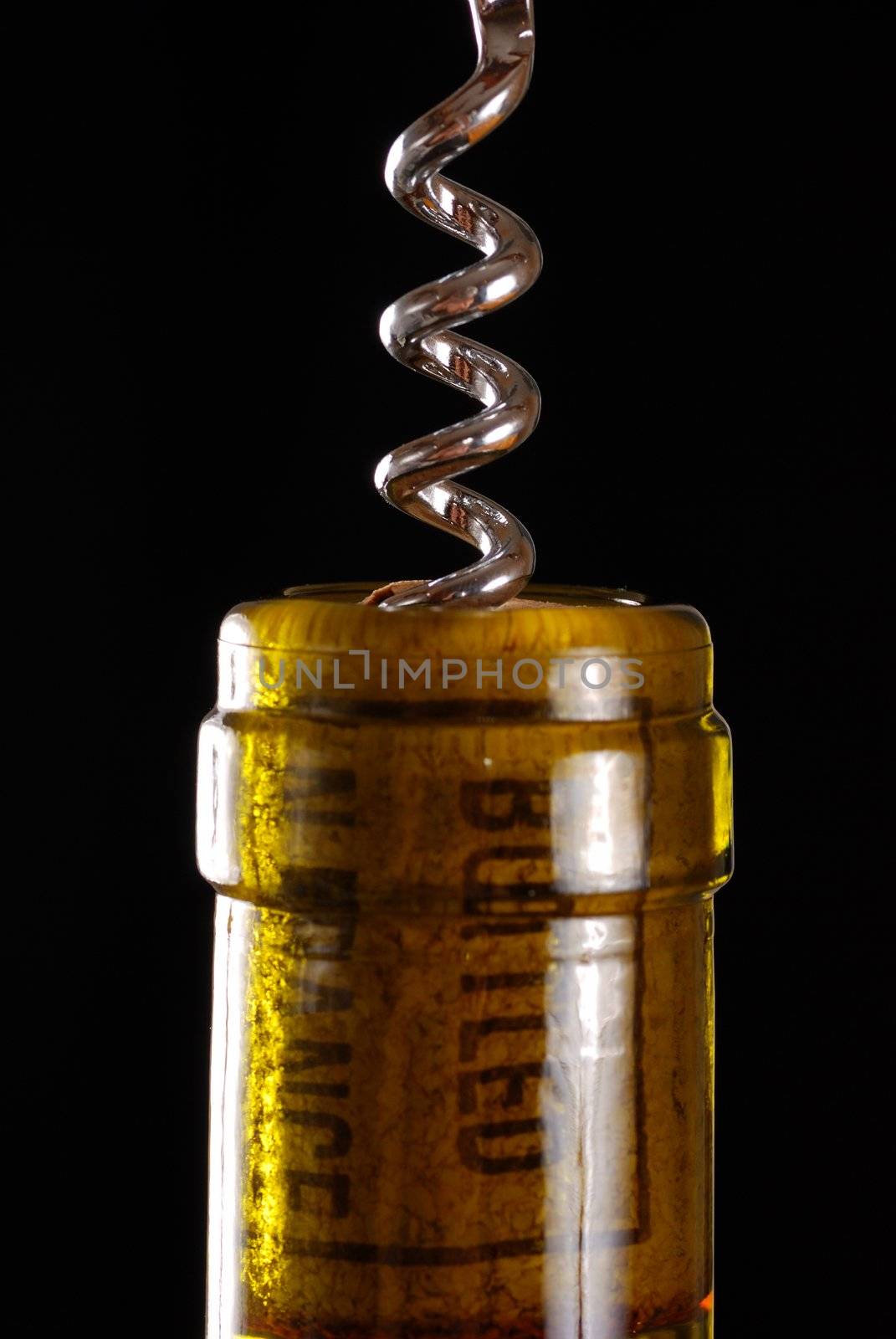 Opening a wine bottle with corkscrew, isolated on black