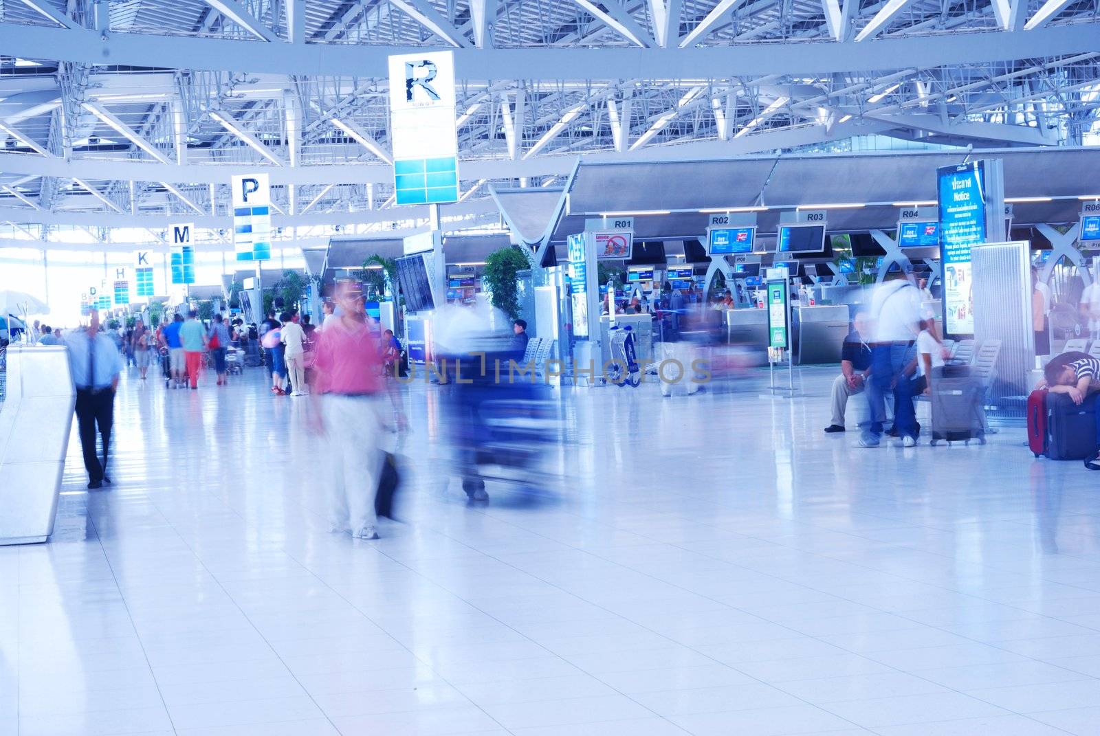 People in airport. Blurred. No recognizable faces or brandnames.