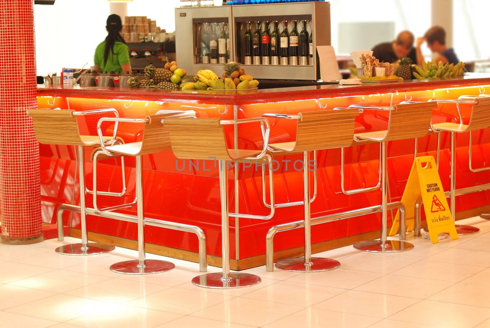 Modern bar in airport. No recognizable faces or brandnames.