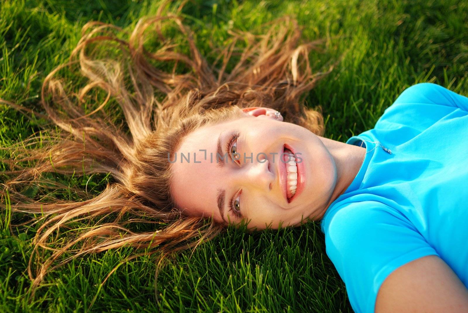 Girl laying on fresh green grass