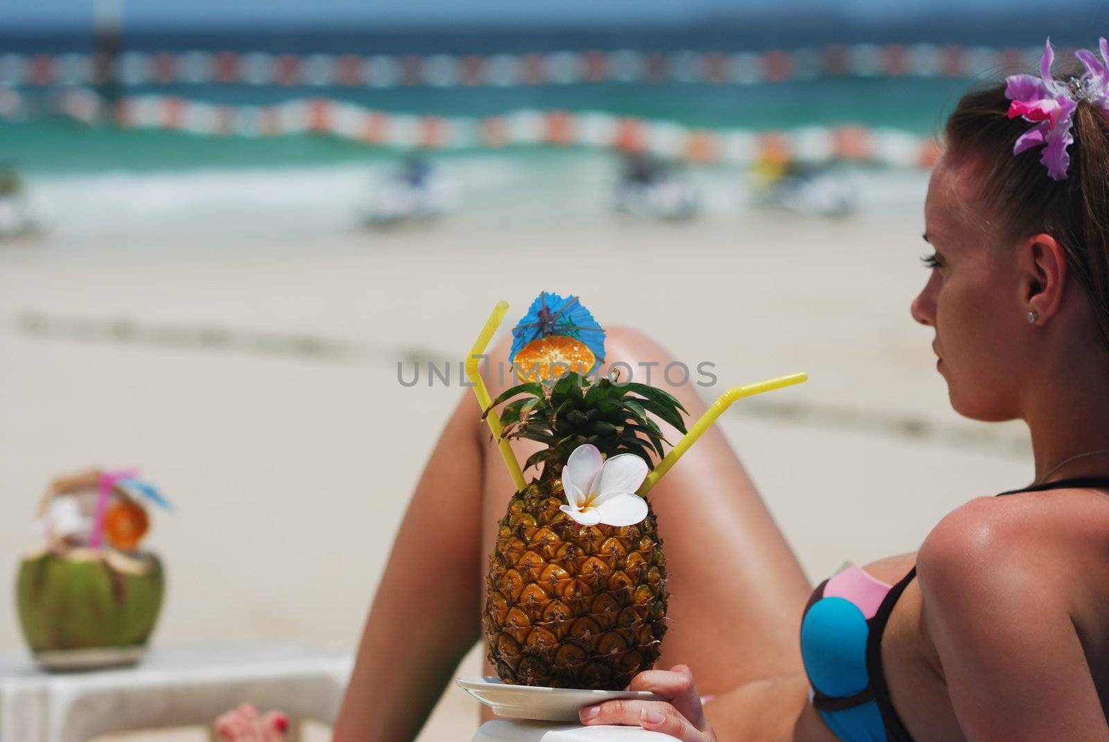 Girl with tropical cocktail on the beach