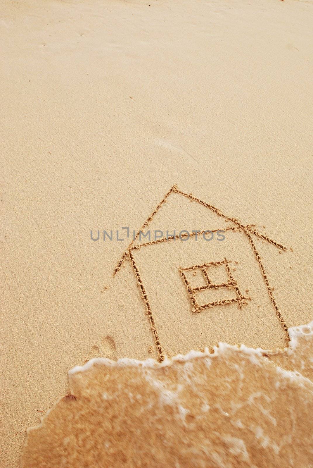 House drawn in sand. Wave blurred.