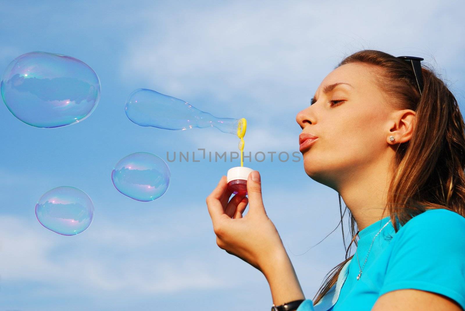 Girl is blowing bubbles outdoors