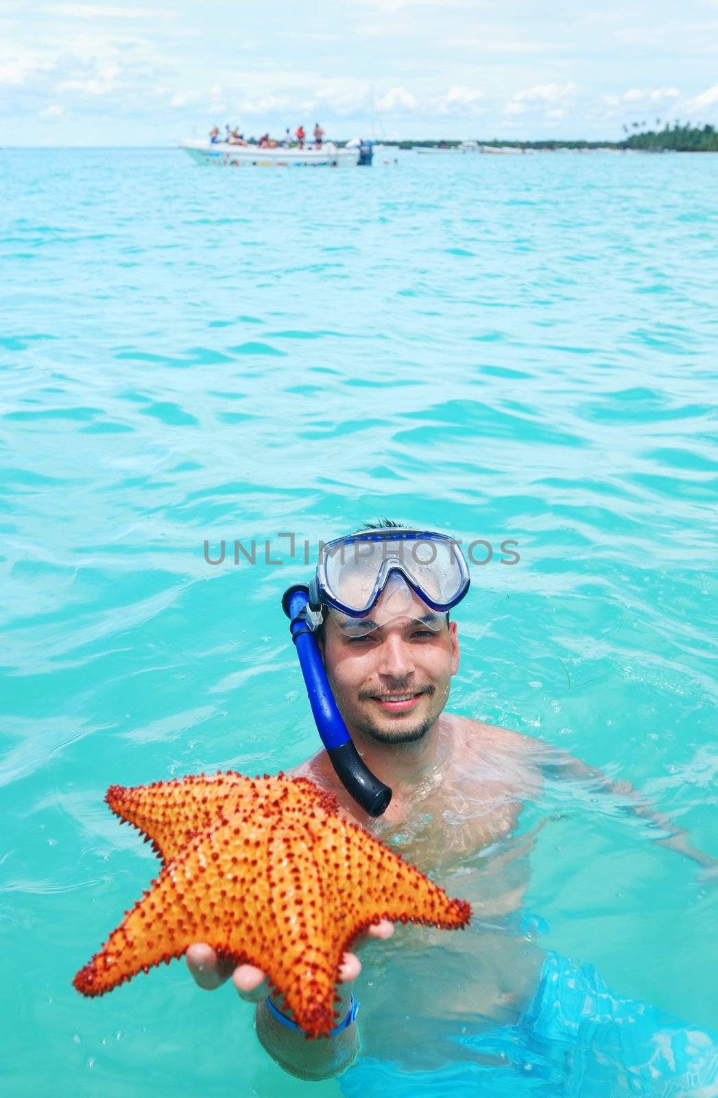 Snorkel man holding red starfish