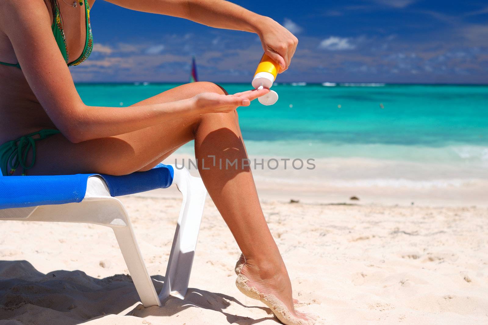 Tan woman applying sun protection lotion