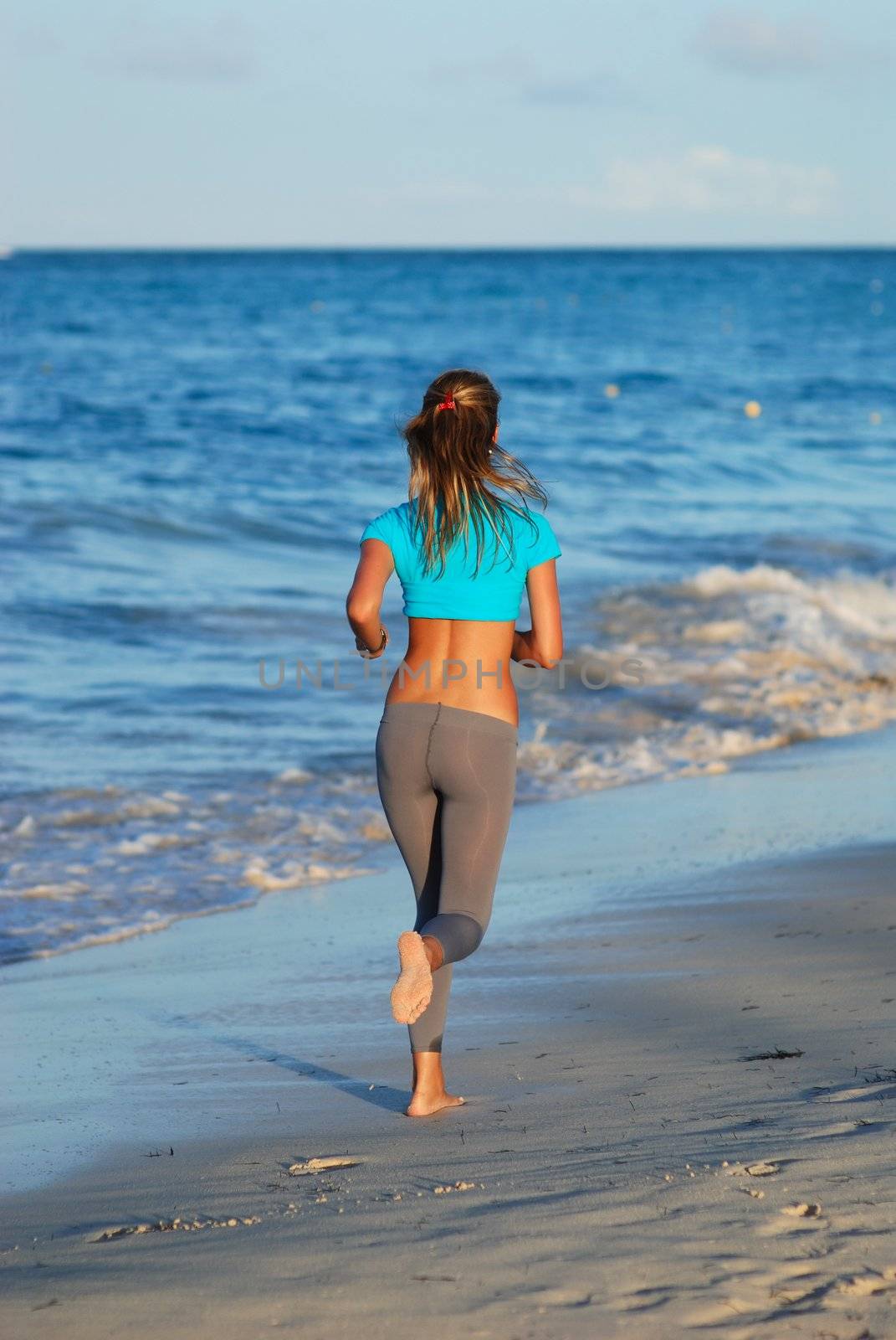 Woman jogging at evening beach