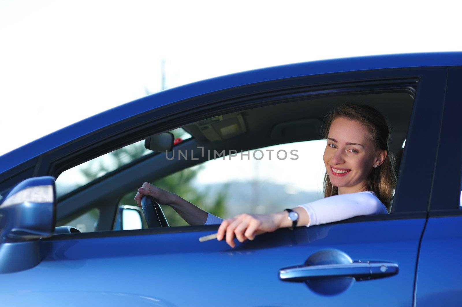 Happy woman in new blue car