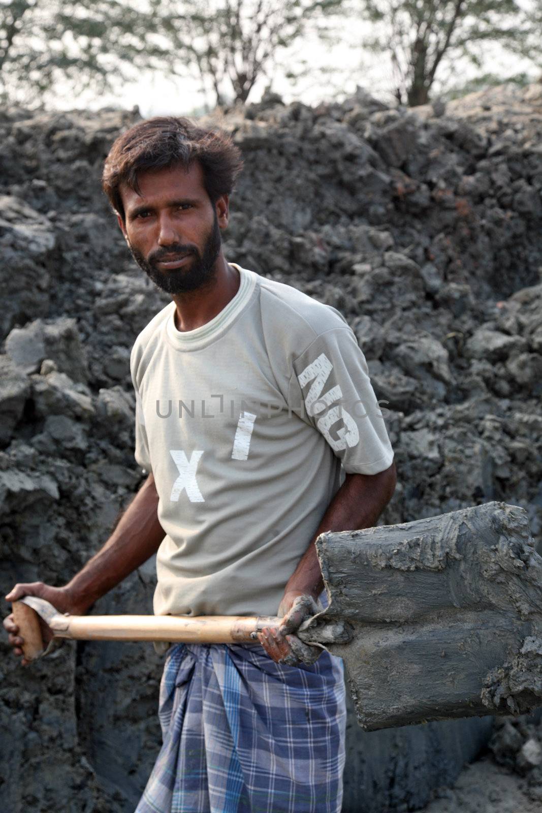 SARBERIA,INDIA, JANUARY 16: Brick field. Laborers are carrying deposited soil for making raw brick. on January 16, 2009 in Sarberia, West Bengal, India.