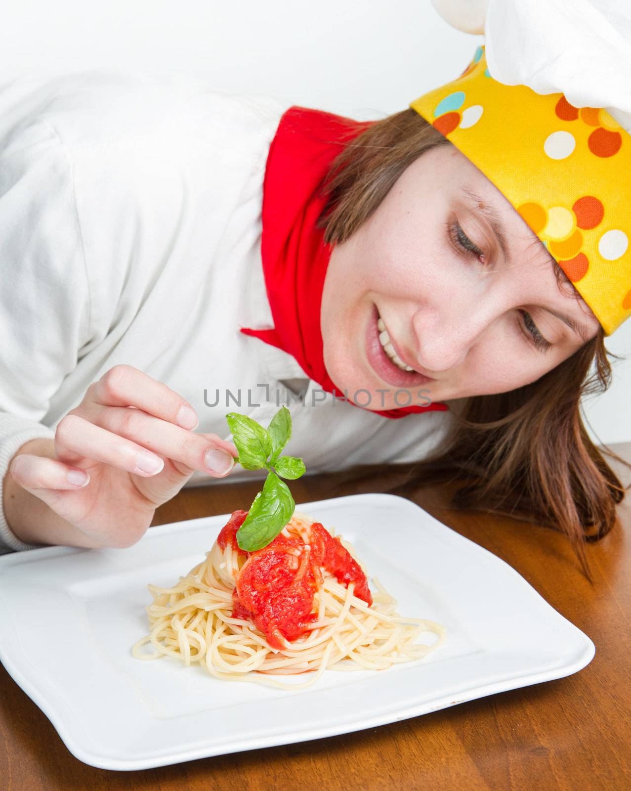  smiling chef garnish an Italian pasta dish 