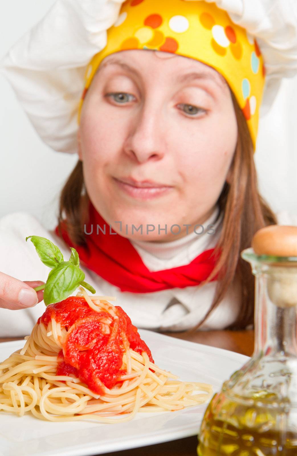  smiling chef garnish an Italian pasta dish 