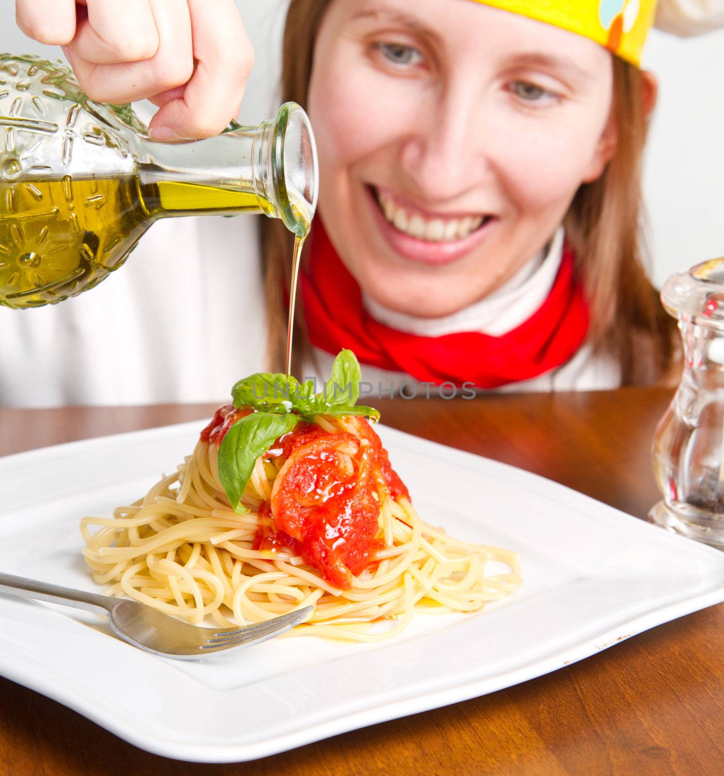  smiling chef garnish an Italian pasta dish 