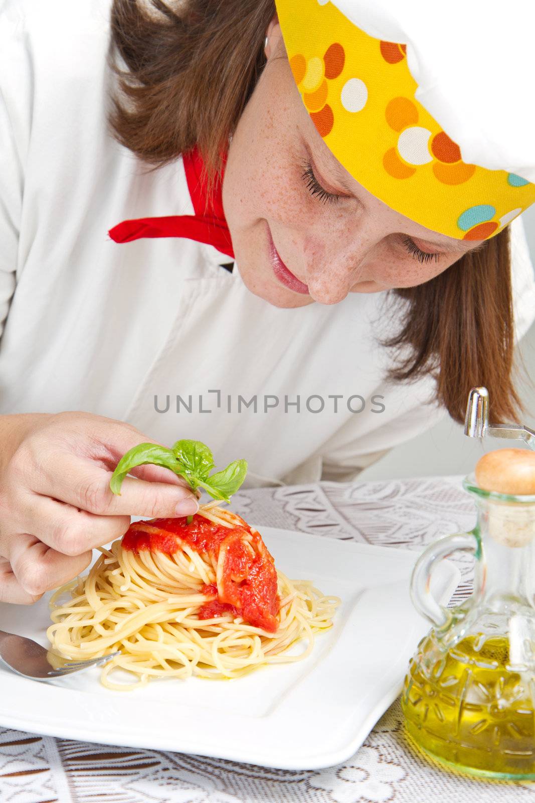  smiling chef garnish an Italian pasta dish 