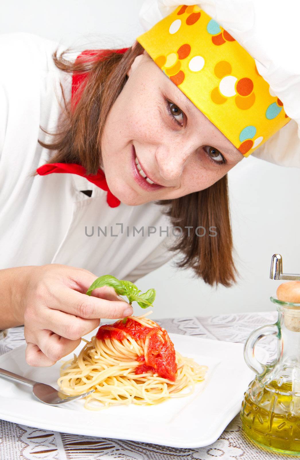  smiling chef garnish an Italian pasta dish 