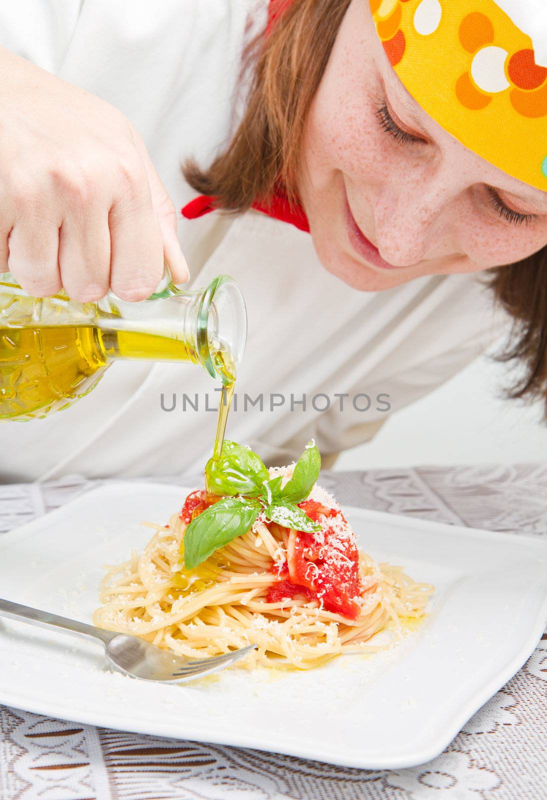  smiling chef garnish an Italian pasta dish 