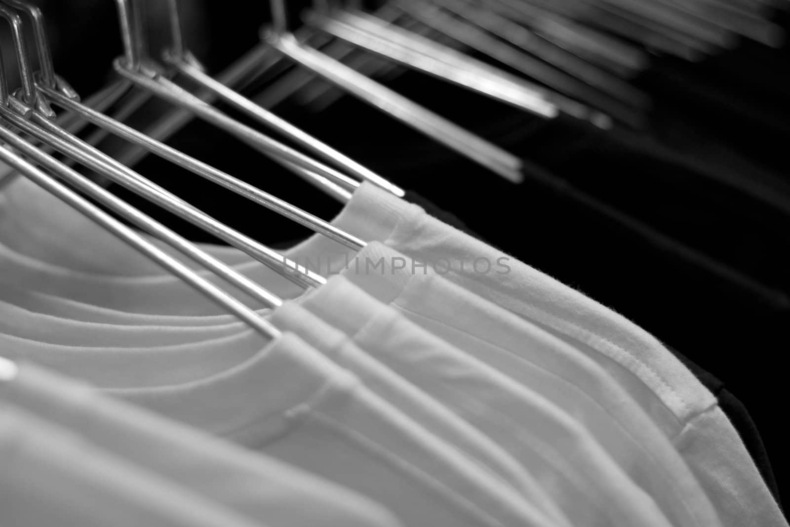 White t-shirts on cloth hangers in row