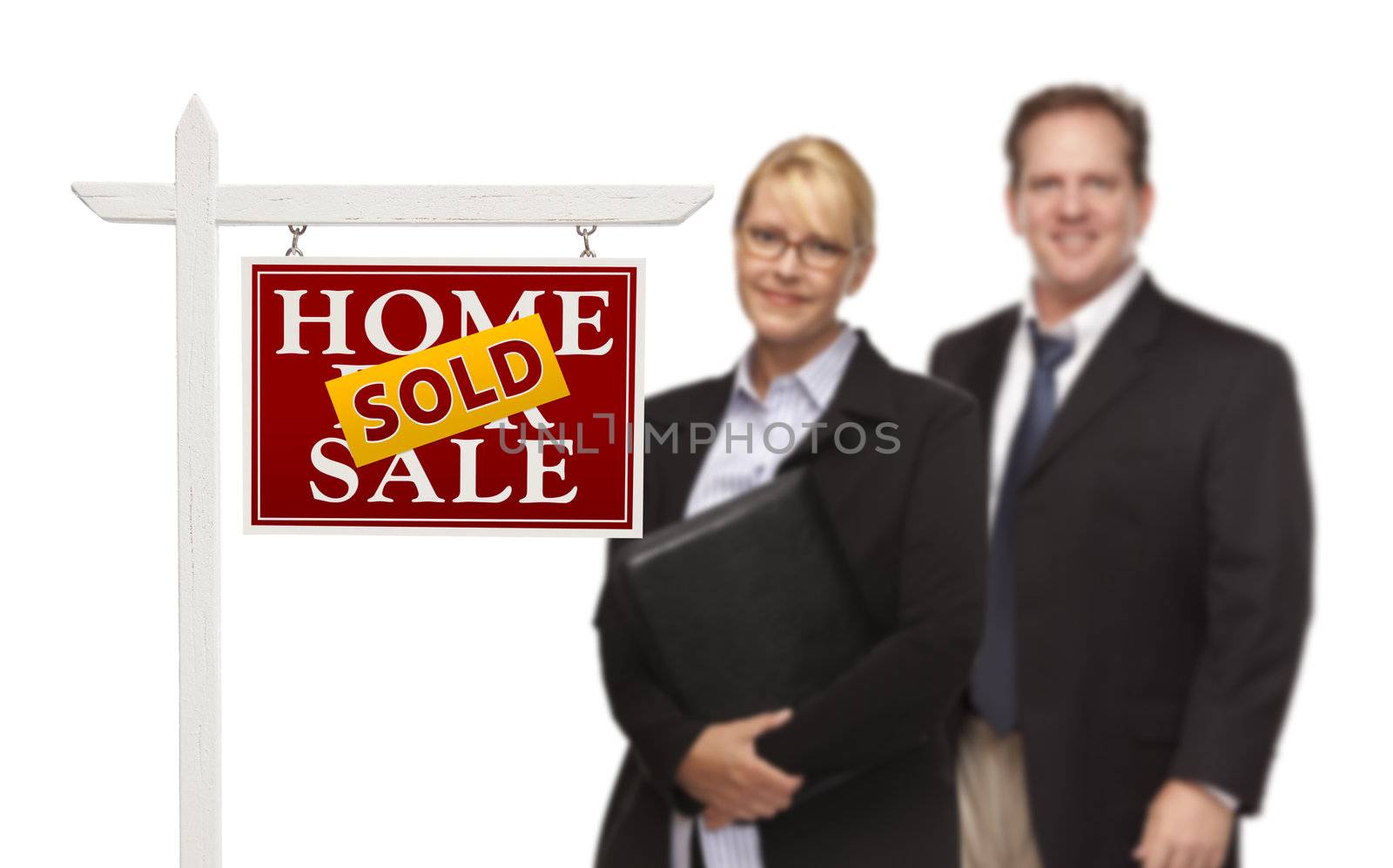 Businesswoman and Businessman Behind Sold Home For Sale Real Estate Sign Isolated on a White Background.