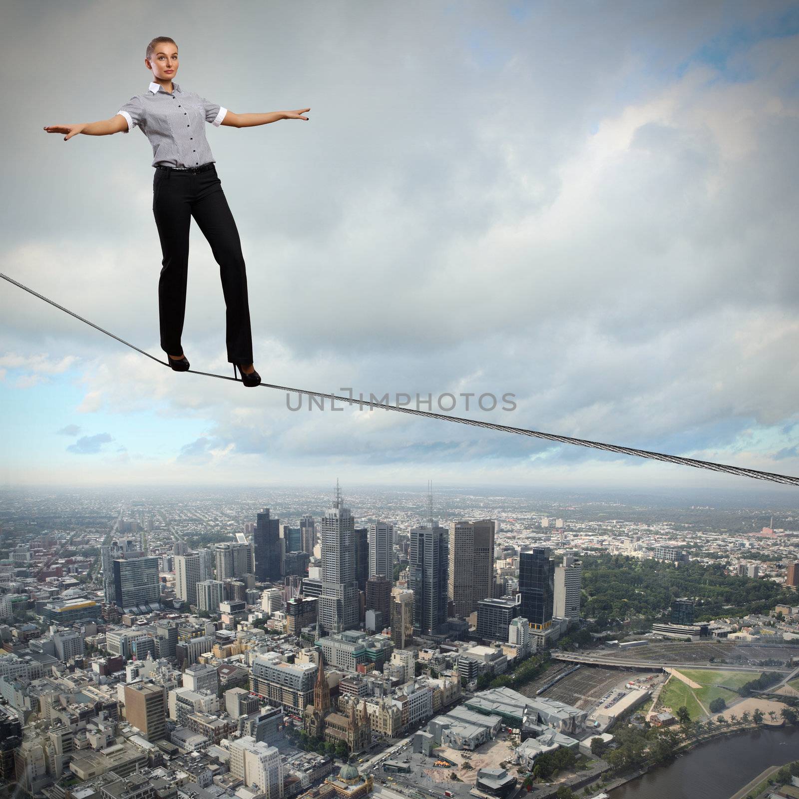 Business woman balancing high over a cityscape