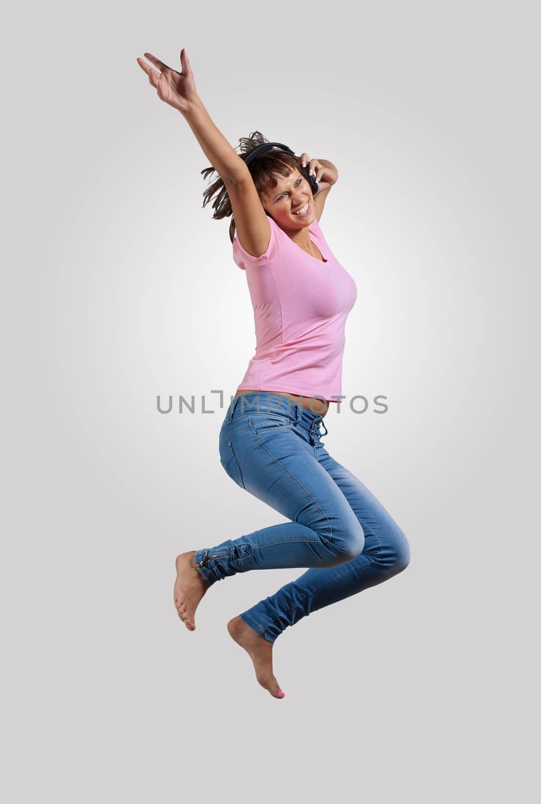 pretty modern slim hip-hop style woman jumping dancing on a colour background